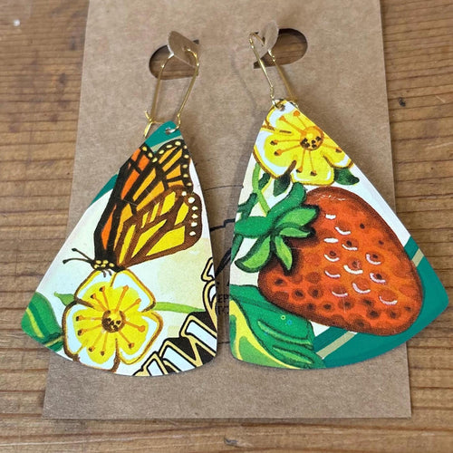Triangular earrings with butterfly and strawberry design on a brown card.