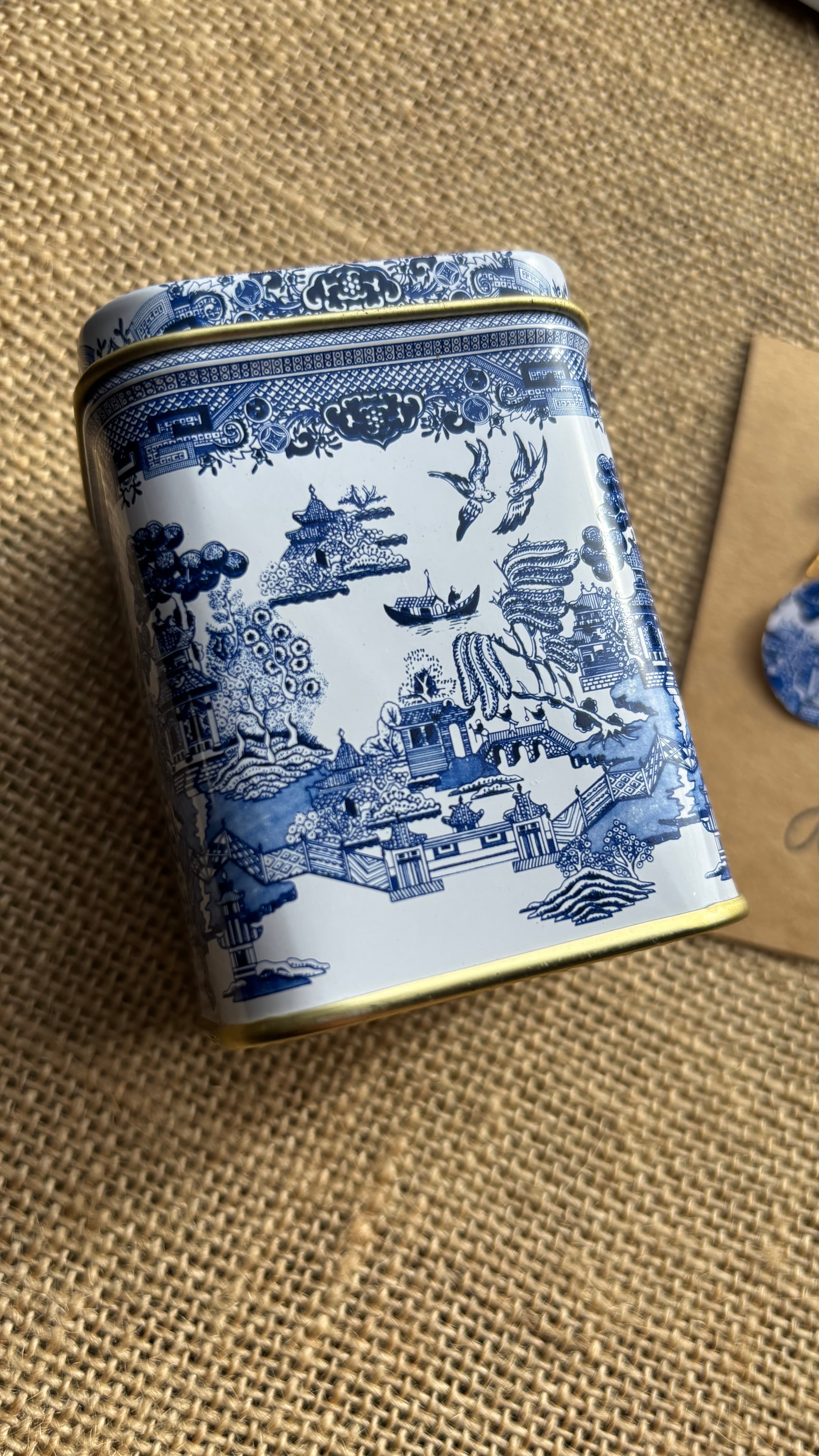 Decorative tin with blue and white pattern on a textured surface